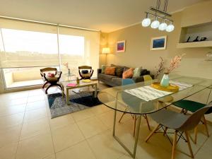 - un salon avec une table en verre et un canapé dans l'établissement Departamento amplio en Laguna Bahia hermosa vista, à Algarrobo