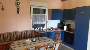 a kitchen with a table and a kitchen with blue cabinets at Family friendly house with a swimming pool Marija Bistrica, Zagorje - 21735 in Marija Bistrica