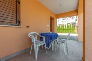 een tafel en stoelen op een veranda met een blauw tafelkleed bij Apartments in Porec - Istrien 44236 in Poreč