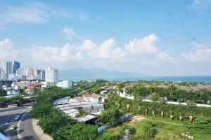 una vista aérea de una ciudad con una carretera y palmeras en Tehana Beach Hotel Da Nang, en Da Nang