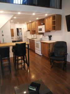 a kitchen with wooden cabinets and a table and chairs at O'Berge du Village A302 in Magog-Orford