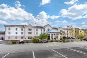 a large white building with a parking lot at MainStay Suites Ocean City West in Ocean City