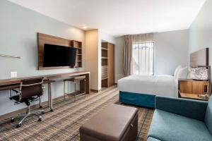 a hotel room with a bed and a desk at MainStay Suites Ocean City West in Ocean City