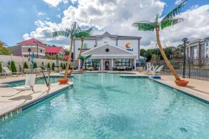 a pool with palm trees in front of a building at MainStay Suites Ocean City West in Ocean City