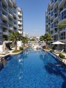 a large swimming pool in front of some buildings at Grand Avenue Pattaya in Pattaya