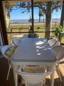uma mesa e cadeiras num alpendre com vista para o oceano em Bayfront, Water View, 5 min to Beach, Pet Friendly em Eastpoint