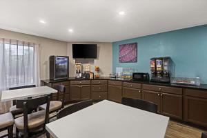 a waiting room with tables and chairs and a tv at Sleep Inn in Lithonia