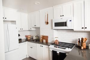a white kitchen with white cabinets and a stove top oven at Sleepover No 103 in Philadelphia