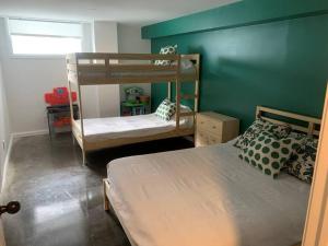 1 dormitorio con 2 literas y una pared verde en Chalet de Mimi en Coaticook