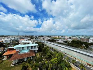 Blick auf eine Stadt mit einem Gebäude in der Unterkunft ＆Monde. Okinawa Arena Condominium in Okinawa