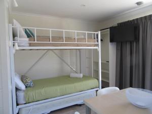 a bedroom with two bunk beds and a table at Tasman Holiday Parks - Merimbula in Merimbula
