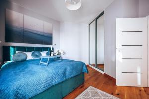 1 dormitorio con 1 cama grande y colcha azul en Wola Tower 3 rooms, 16th floor with a view, 80m2, free garage, en Varsovia