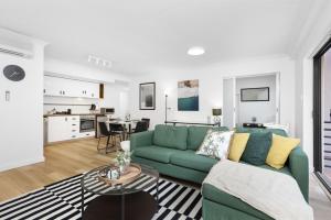 a living room with a green couch and a kitchen at 212 Boho Chic in Perth