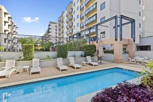 an image of a swimming pool with chairs and a building at 212 Boho Chic in Perth