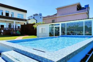 a swimming pool in front of a house at Ecotourism skim month B & B in Xiaoliuqiu