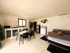 - une chambre avec un lit et une salle à manger avec une table dans l'établissement MOOREA - O Motu, à Temae