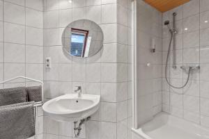 y baño blanco con lavabo y ducha. en Family&Friends 2, en Ludwigshafen