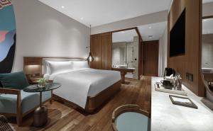 チャングーにあるHoliday Inn Resort Bali Canggu, an IHG Hotelのベッドとデスクが備わるホテルルームです。