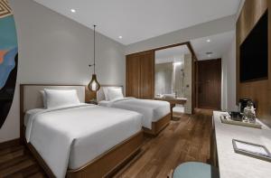 a hotel room with two beds and a bathroom at Holiday Inn Resort Bali Canggu by IHG in Canggu