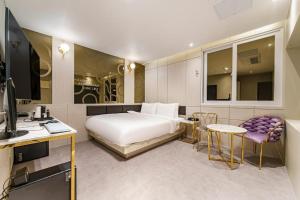 um quarto de hotel com uma cama, uma mesa e cadeiras em Hotel Bon em Tongyeong