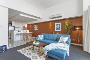 Il comprend un salon avec un canapé bleu et une cuisine. dans l'établissement U8/51 Bright 3 bd city, à Perth