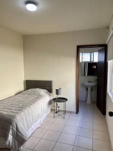 a bedroom with a bed and a table and a sink at Casa Tehuantepec, 5hab 4.5baños in Hermosillo