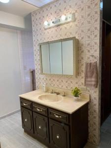 a bathroom with a sink and a mirror at Casa Tehuantepec, 5hab 4.5baños in Hermosillo
