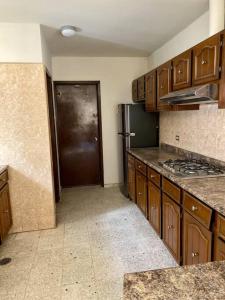 a kitchen with wooden cabinets and a black door at Casa Tehuantepec, 5hab 4.5baños in Hermosillo
