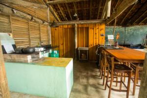 een keuken met een aanrecht en een tafel en stoelen bij 5 suítes-Cond. fechado- Vista para a Barra do Sahy in São Sebastião