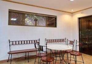 Zimmer mit einem Tisch, Stühlen und Fenstern in der Unterkunft Lovely & Spacious Family House in Tagaytay in Tagaytay