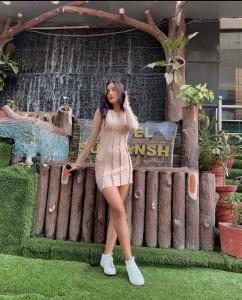 a woman in a dress standing next to a fence at Hotel Suryansh Pvt Ltd in Heṭauḍā