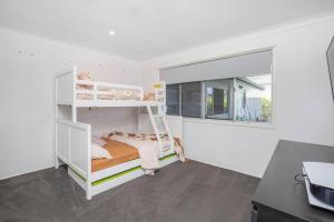 ein Schlafzimmer mit zwei Etagenbetten und einem Fenster in der Unterkunft Stunning Entertainer with private beach in Gold Coast + 12 Fotos