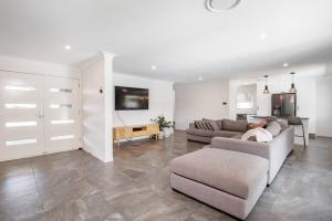 ein großes Wohnzimmer mit zwei Sofas und einem Tisch in der Unterkunft Stunning Entertainer with private beach in Gold Coast