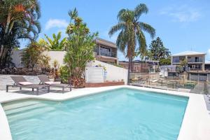 ein Swimmingpool mit zwei Stühlen und einem Haus in der Unterkunft Stunning Entertainer with private beach in Gold Coast