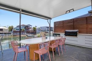 eine Terrasse mit Tisch und Stühlen und Blick auf das Wasser in der Unterkunft Stunning Entertainer with private beach in Gold Coast