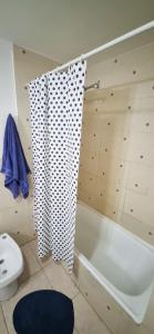 ein Bad mit einem Duschvorhang und einem WC in der Unterkunft CASA COMPLETA 2 PLANTAS CON EXTRAORDINARIA VISTA AL CANAL BEAGLE CENTRICA 4pax in Ushuaia