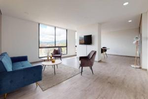 a living room with a blue couch and chairs at Apto 2 habitaciones Comfort Kappa in Bogotá