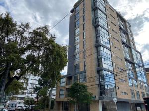 a tall building with a clock on the side of it at Apto 2 habitaciones Comfort Kappa in Bogotá