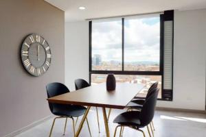 a dining room with a table and chairs and a clock at Apto 2 habitaciones Comfort Kappa in Bogotá