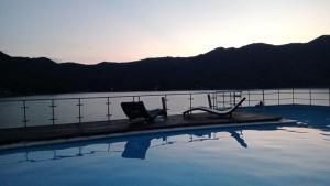 une piscine avec deux chaises assises au bord de l'eau dans l'établissement Isla Privada al interior de Colombia en Prado Tolima, à Prado