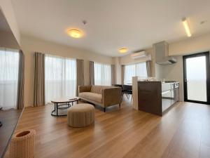 ein Wohnzimmer mit einem Sofa und einem Tisch in der Unterkunft ＆Monde. Okinawa Arena Condominium in Okinawa