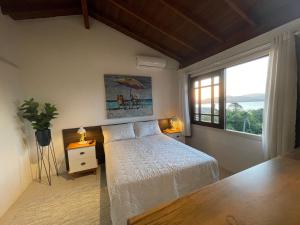 Un dormitorio con una cama y una ventana grande. en Pousada Miradouro, en Imbituba 69 fotos más