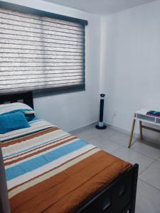 - une chambre avec un lit et une fenêtre avec des stores dans l'établissement Claudia y Elías, à Guadalajara