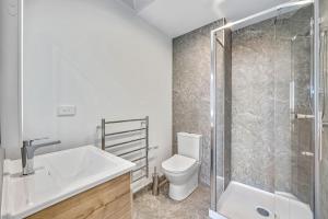 a bathroom with a toilet and a sink and a shower at Central Park Residence in Auckland +7 photos