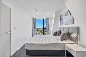 a bedroom with a large bed and a window at Central Park Residence in Auckland