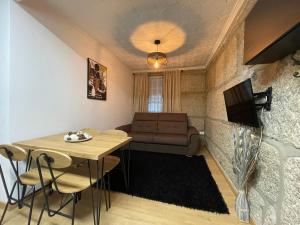 uma sala de estar com uma mesa e um sofá em Apartamentos A'Dao em Nelas