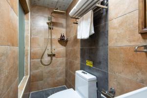 ein Badezimmer mit Toilette und Dusche in der Unterkunft The East Hotel--The Forbidden City,Beijing Drum Tower, Nanluoguxiang Hutong, Houhai Bar Street,Beijing's Historic Hutongs in Peking