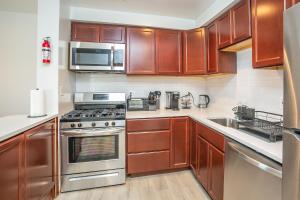 a kitchen with wooden cabinets and stainless steel appliances at Comfy and Cozy-Min to National Mall Great Location in Arlington