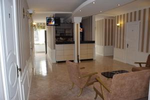 a living room with a table and chairs and a kitchen at Crossway Tbilisi Hotel in Tbilisi City