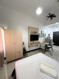 um quarto com uma cama, uma mesa e uma televisão em San Marino Residences em Cebu